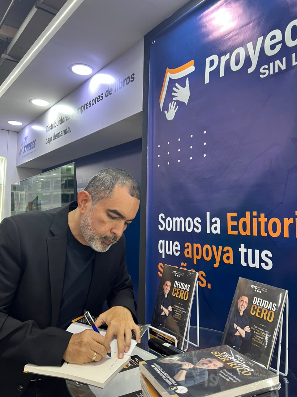 Autor firmando ejemplares de su libro en el stand de Proyectos Sin Limites